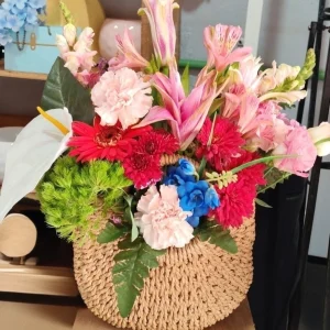 Bolsa tejida especial y una mezcla de flores rojas y rosa, un detalle para celebrar cualquier ocasión